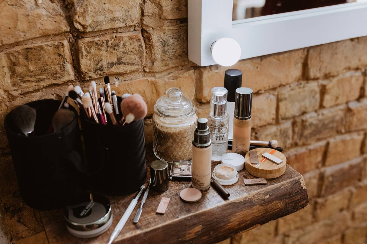 A sturdy rotating makeup organizer solution holding brushes, compacts, and serums on a well-lit vanity